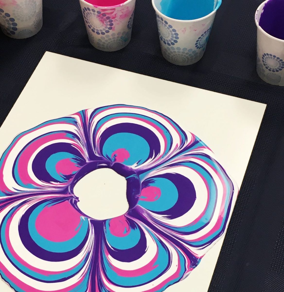 Acrylic paint-pouring activity with pink, blue and white marbled effect