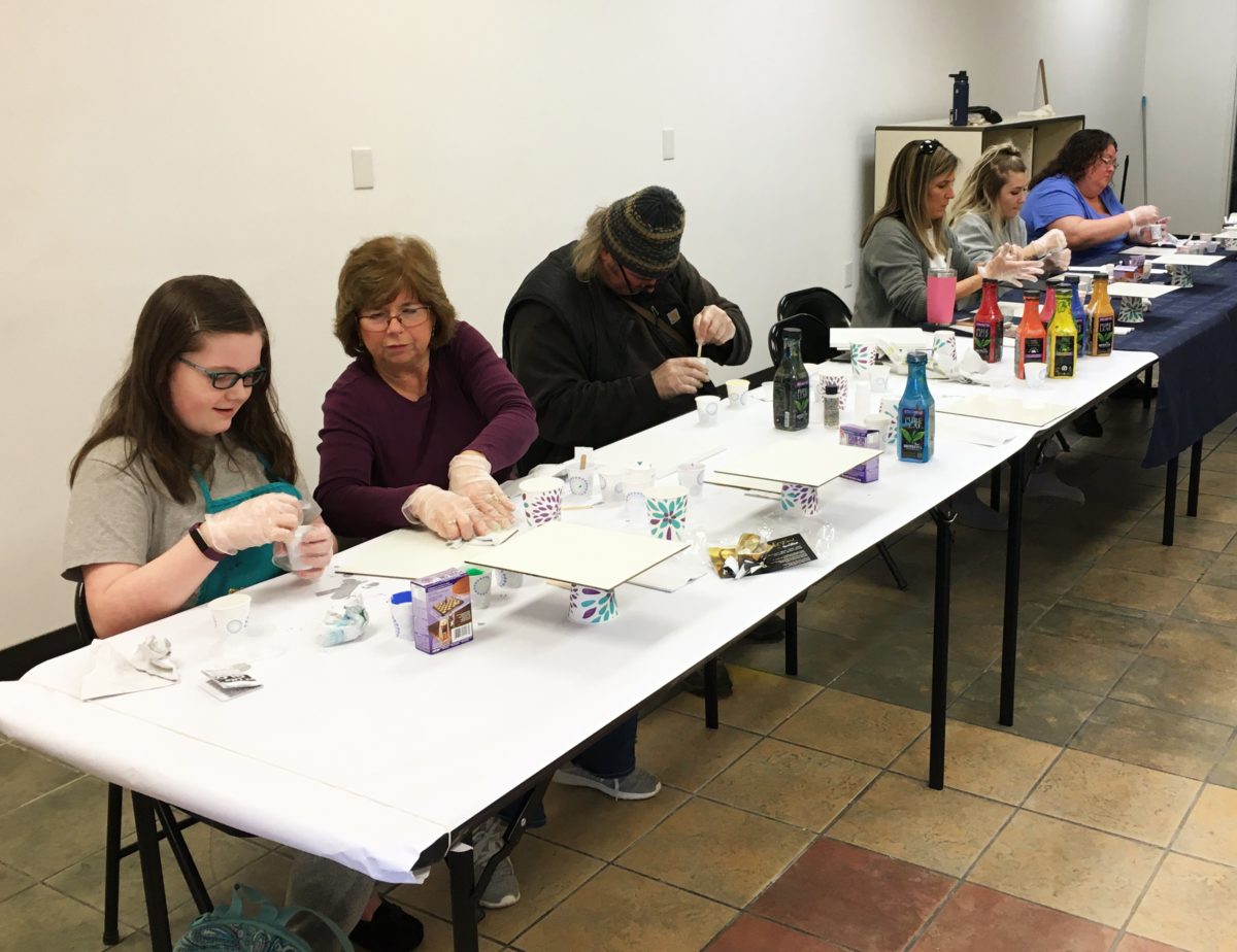 People in a paint-pouring class at an art supply store